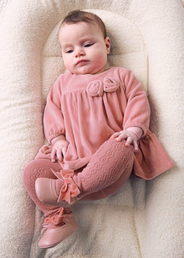 Baby girl in a Mayoral pink velour dress with rose details, openwork tights and bow shoes